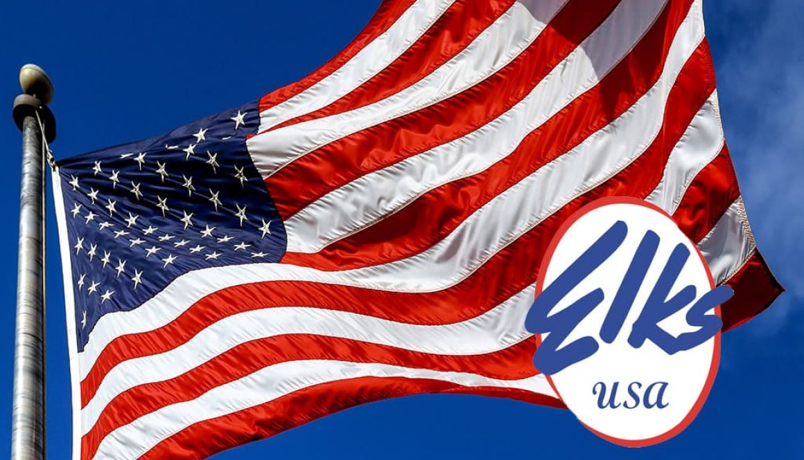 USA. Wind blown flag of the United States of America over sky background.