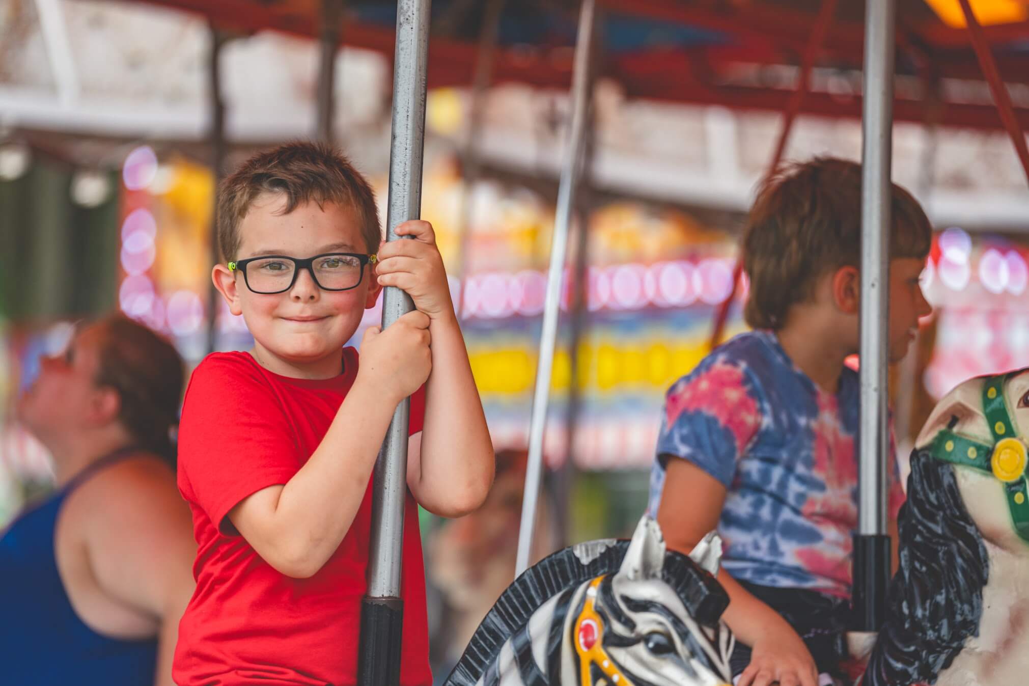 Child smiling on a carousel at the Ashville Fourth of July celebration