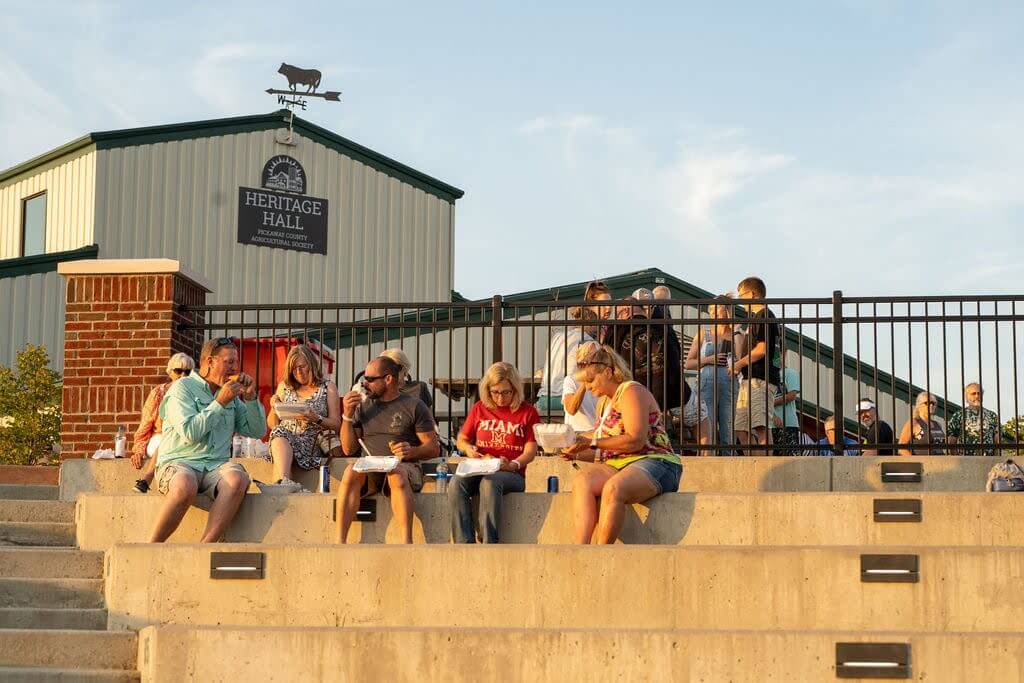 Visitors enjoying food at the Pickaway County Food Truck Festival outside Heritage Hall