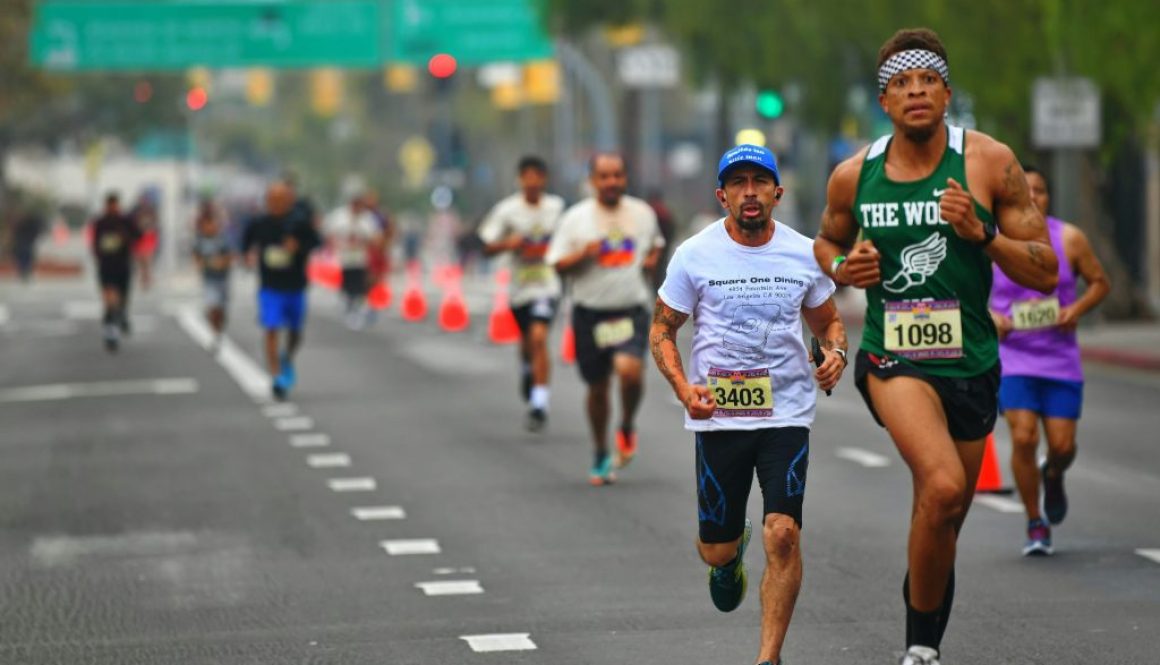 Runners with race bibs competing on a city street during the Circleville Classic 5K Race