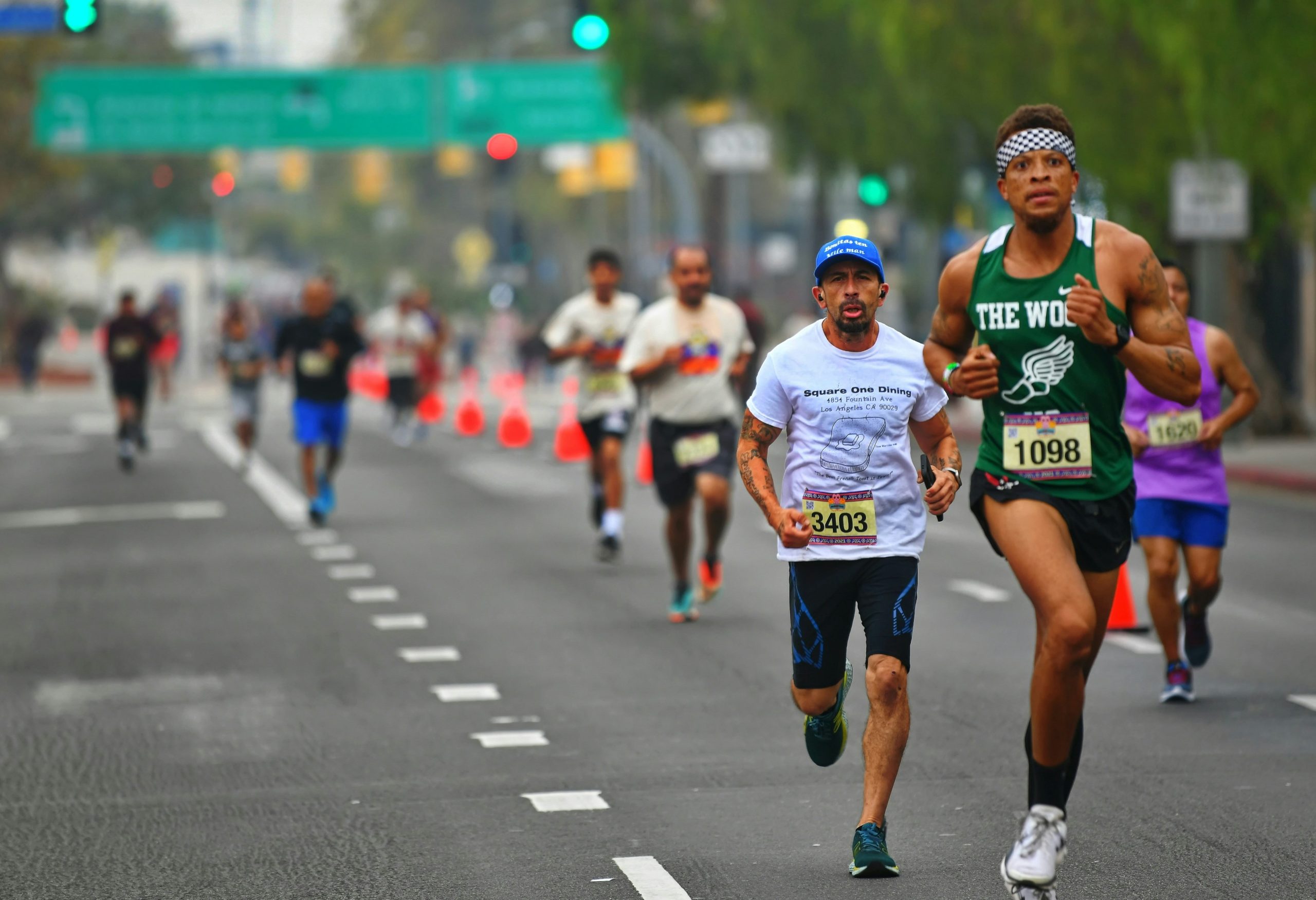 Runners with race bibs competing on a city street during the Circleville Classic 5K Race