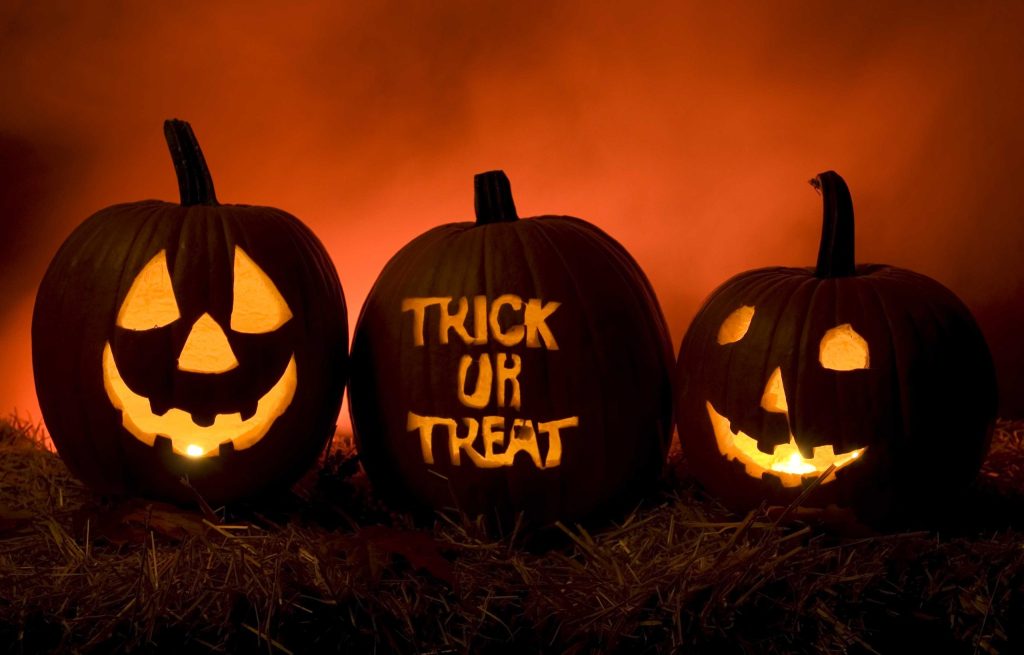 Three glowing jack-o'-lanterns, the center one carved with "Trick or Treat"