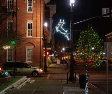 Downtown Circleville at night with a light-up reindeer and a tree wrapped in Christmas lights